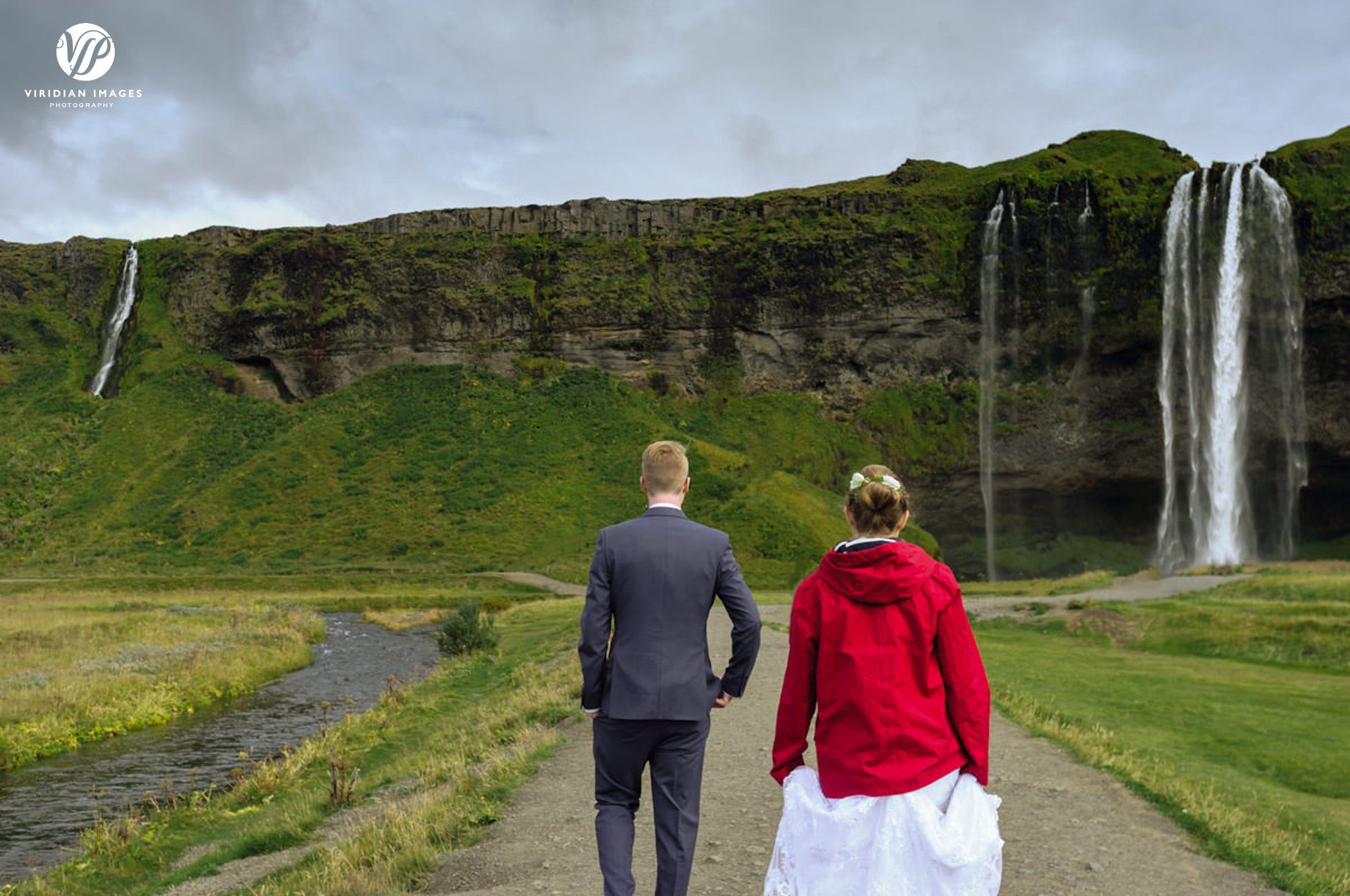 Bride and groom walking to Seljalandsfoss
