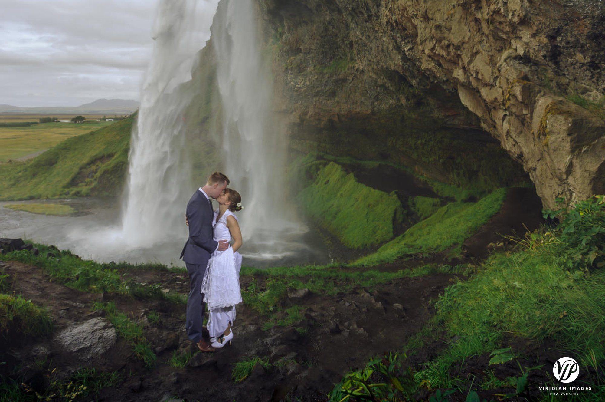 Kissing under Seljalandsfoss waterfall in Iceland