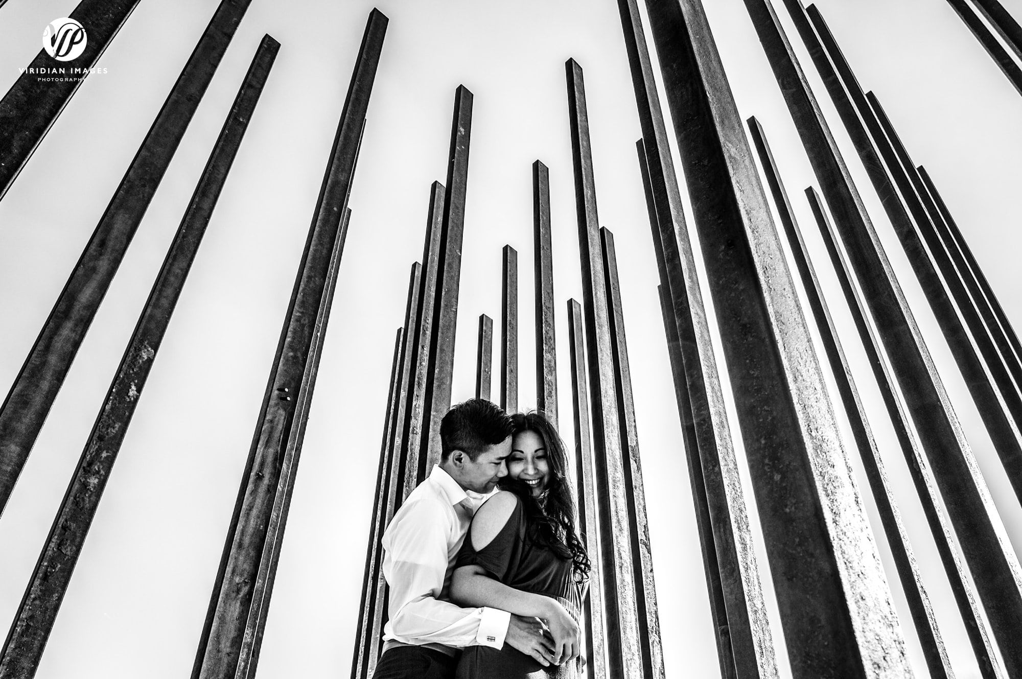 couple hug from below metal posts