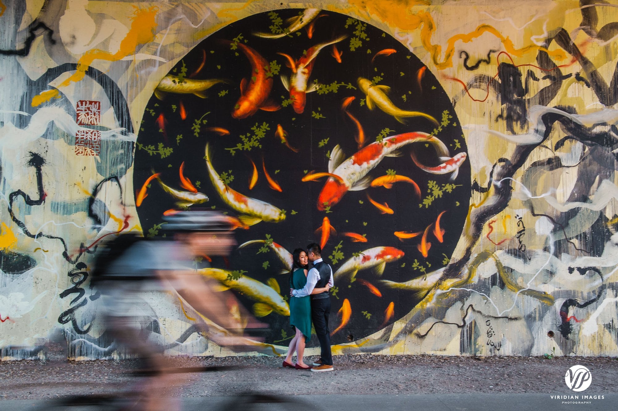 couple facing fish mural beltline with cyclist