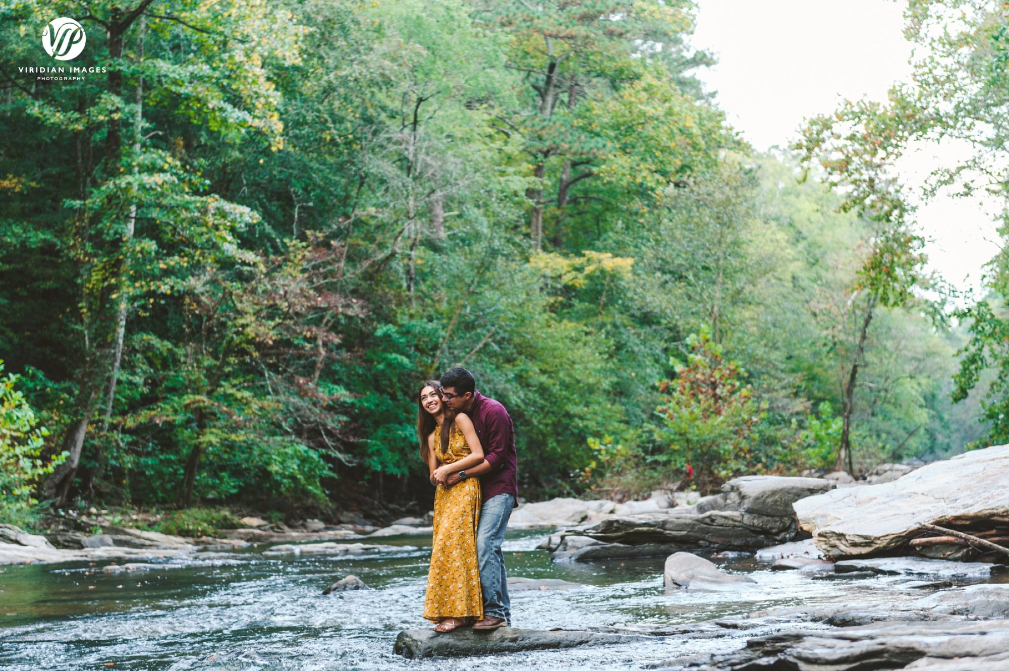 couple hugging on rock middle of chattahoochee river