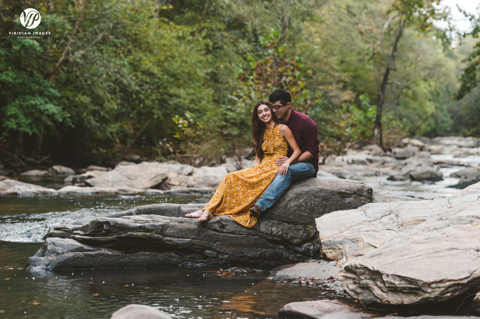 couple sitting on rock of chattahoochee river