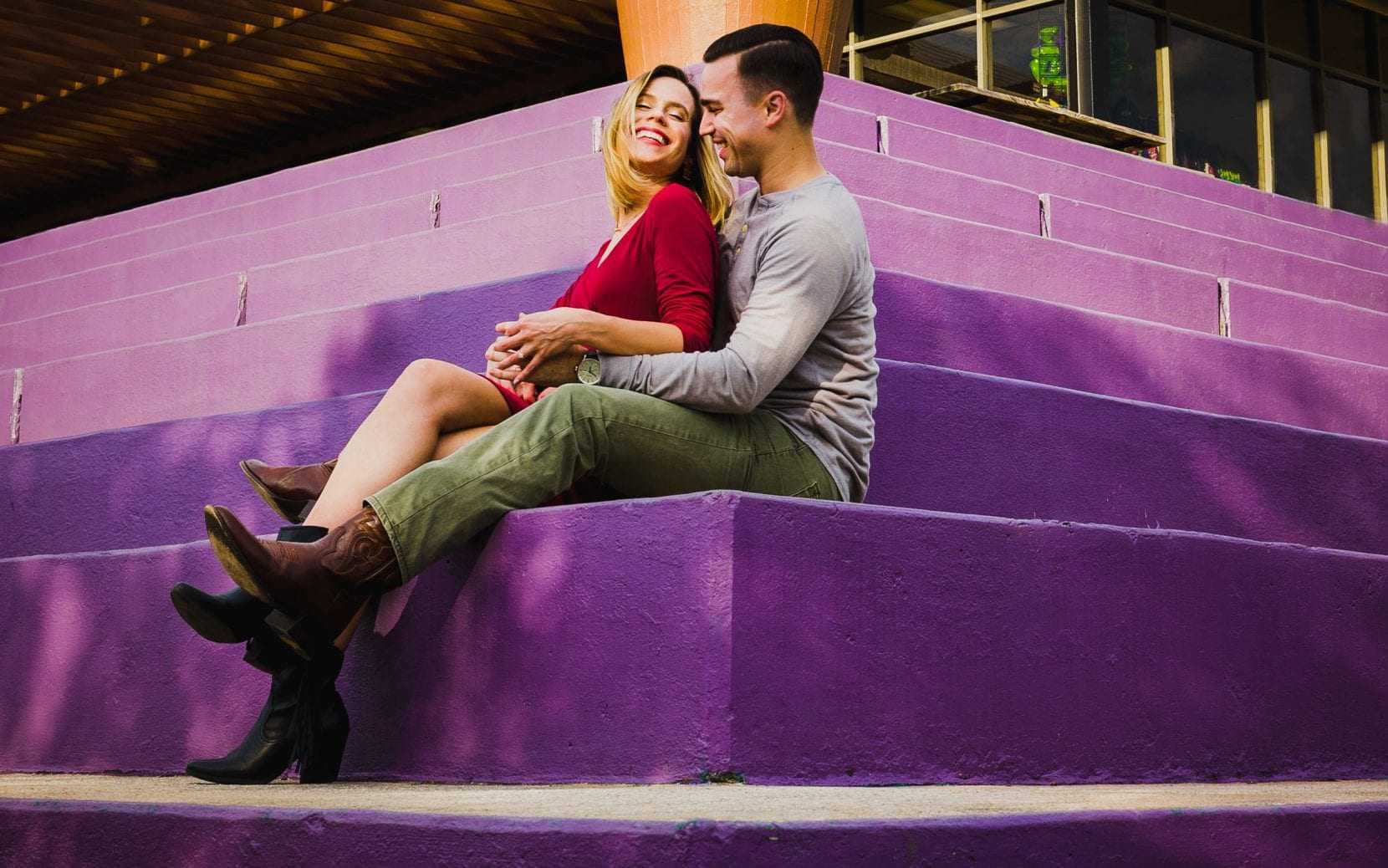 happy couple sitting purple stairs engagement