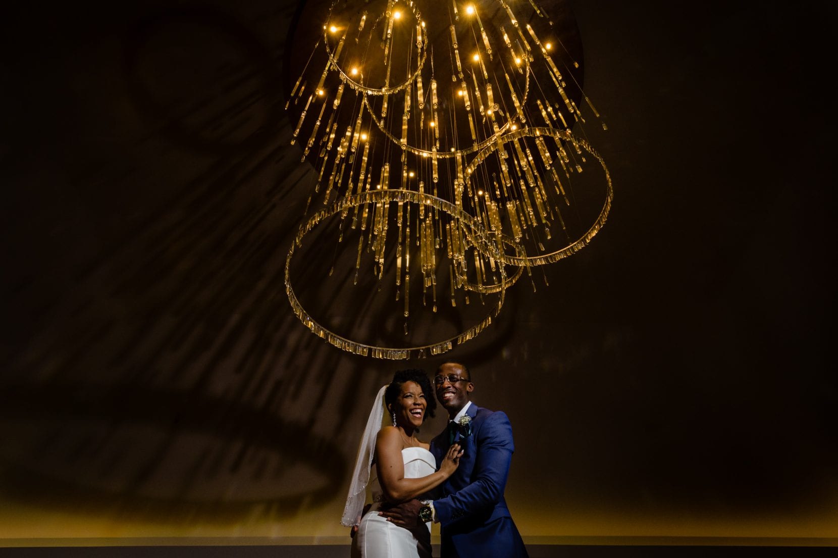 wedding couple under chandelier