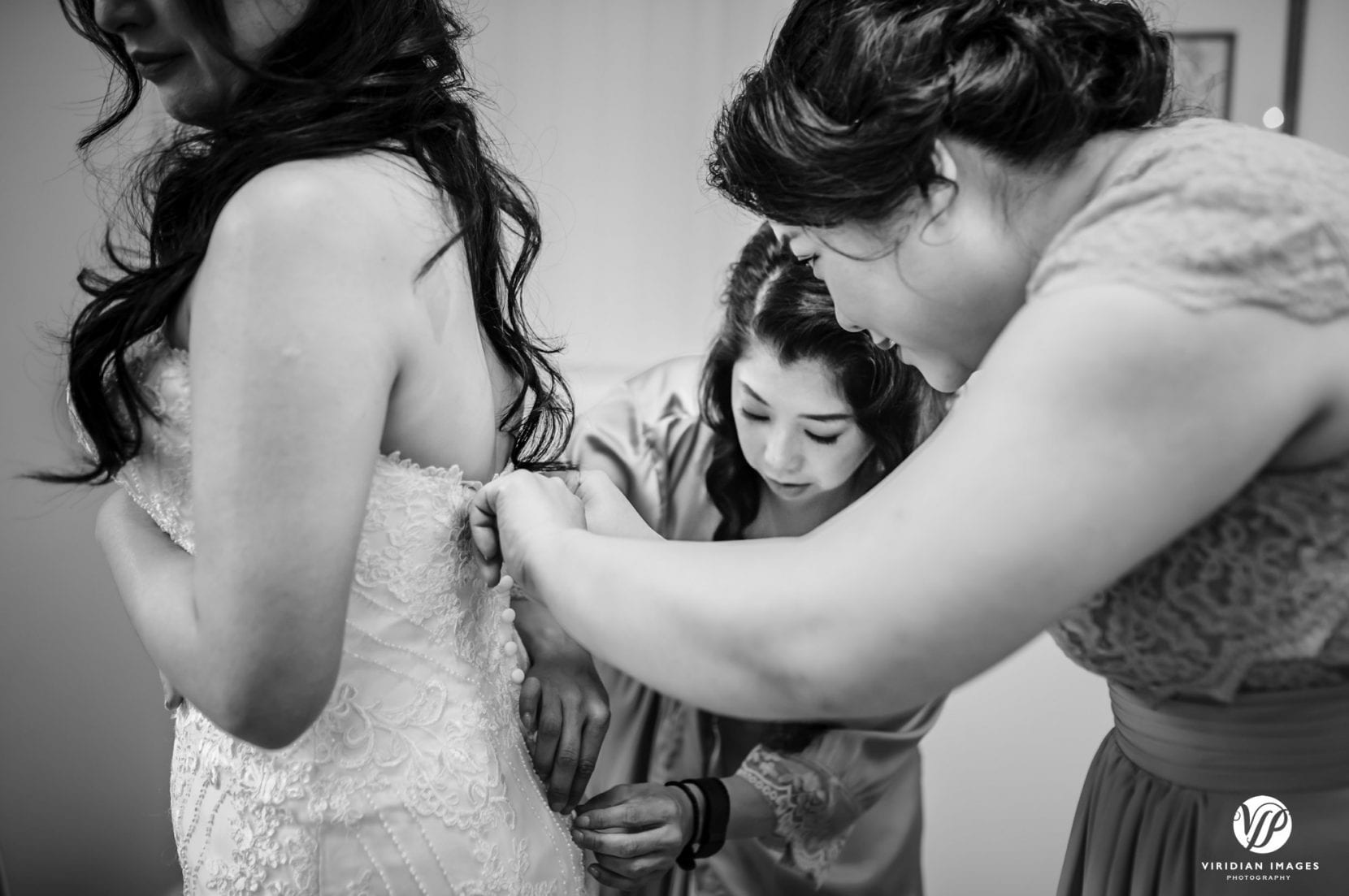 bridesmaids helping bride wedding dress