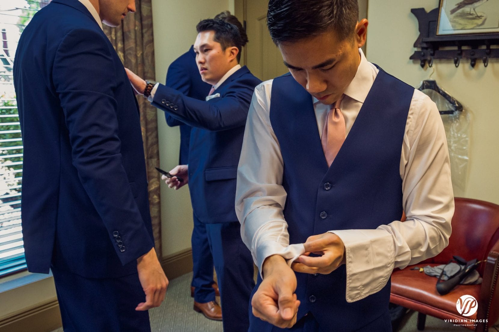 groom putting on cufflinks getting ready