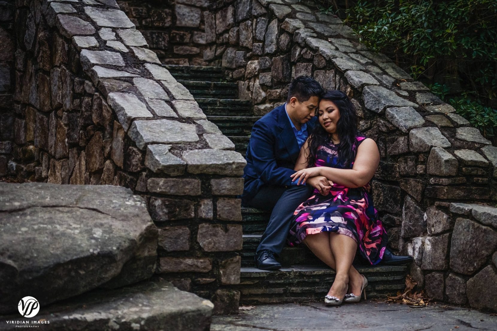 couple sitting on stone stairs dusk in stone mountain park atlanta engagement photo