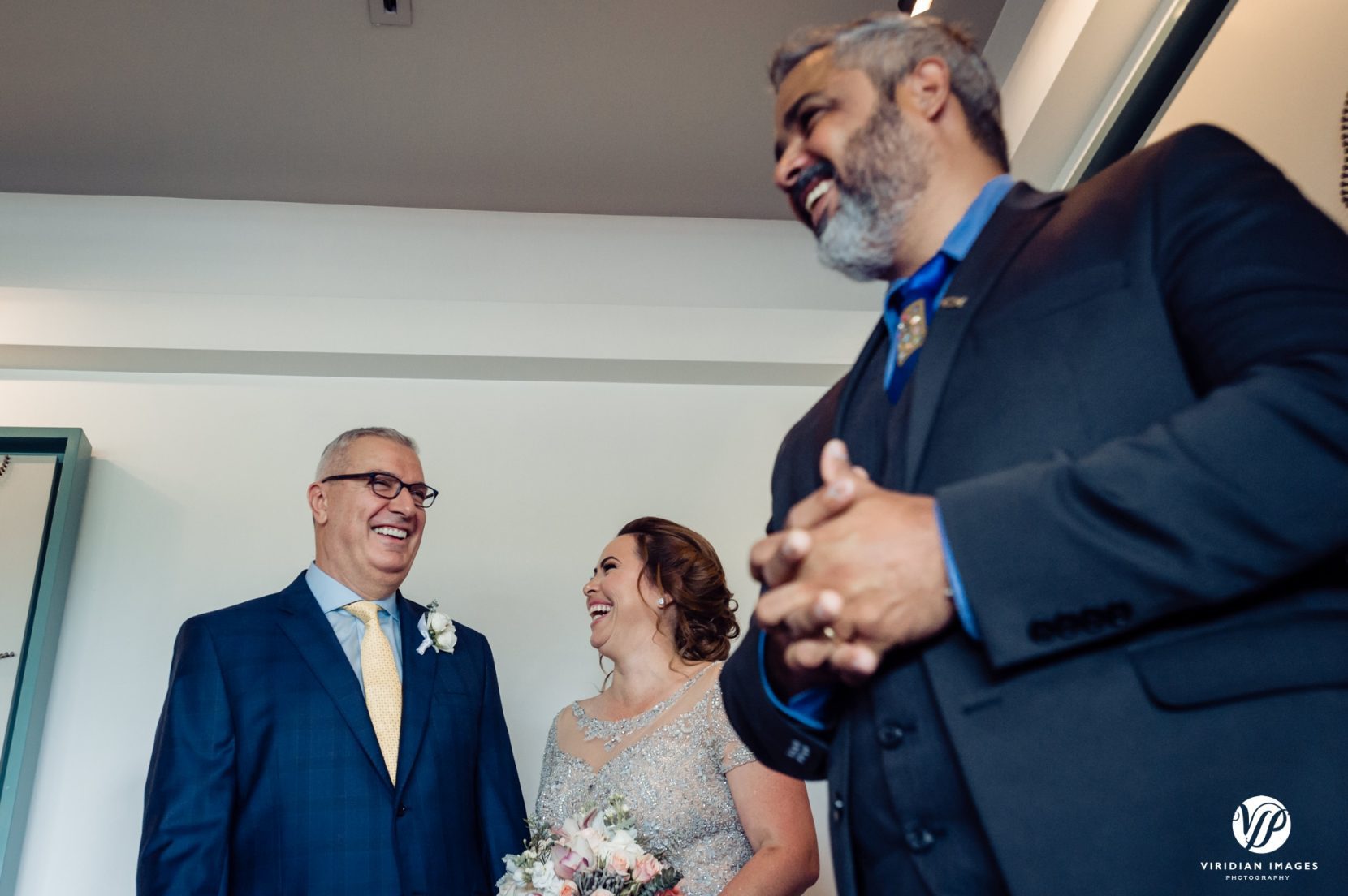 bride, groom and officiant laughing