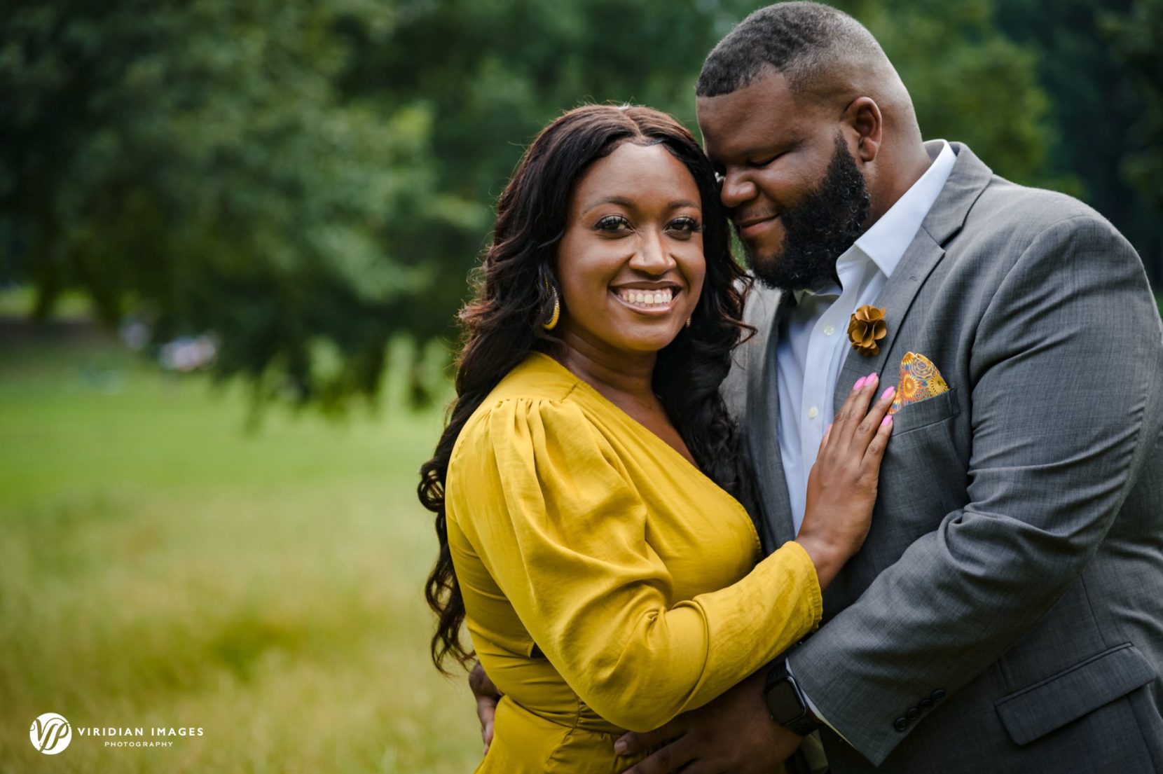 Closeup portrait of engaged couple on grassy field at Piedmont Park