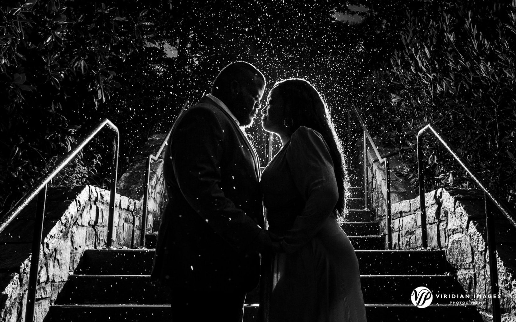 Raindrops highlighted dramatically around couple during evening portraits