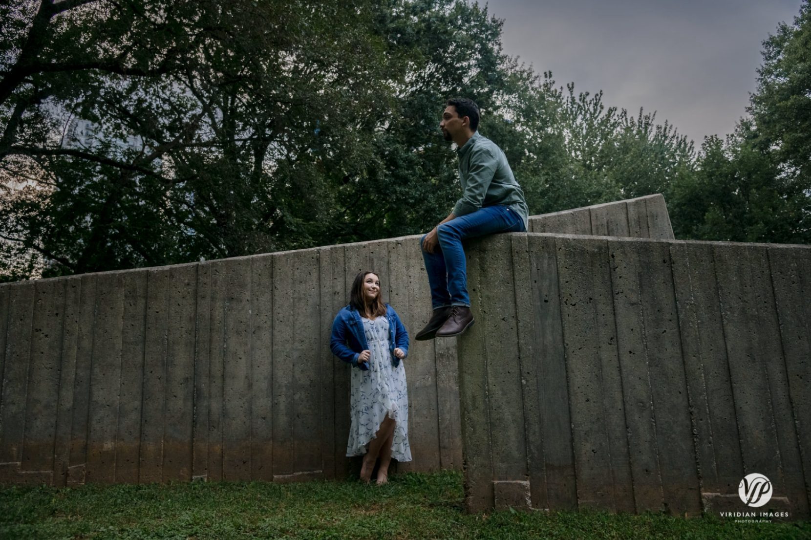 Editorial style photo of couple against concrete art installation during engagement session in Atlanta
