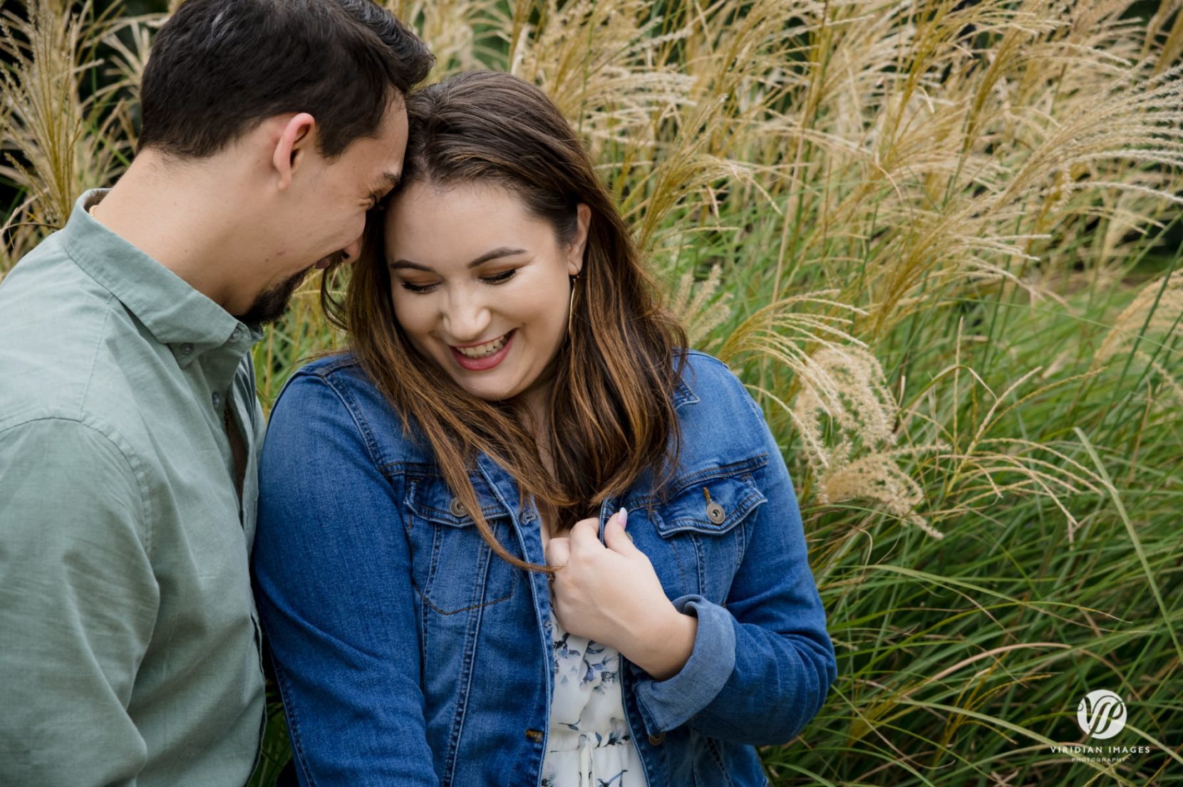 Playful moment with bride-to-be being flirty against blowing fountain grass