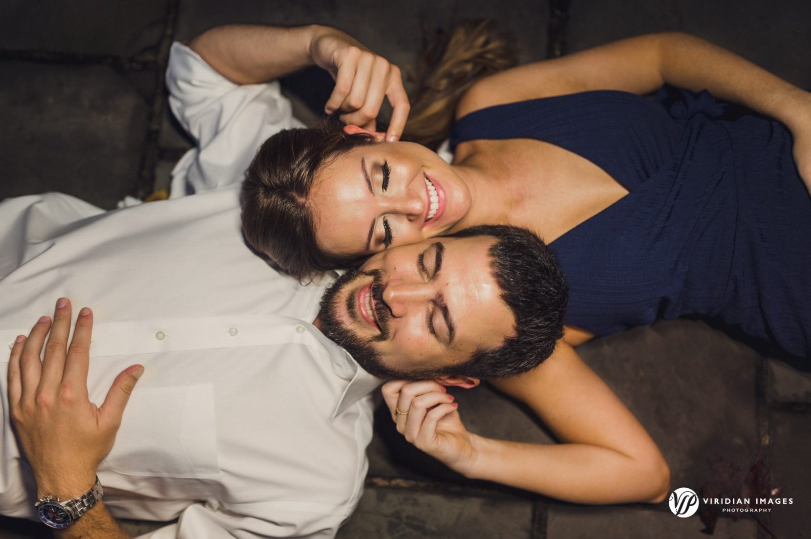 playful photo of couple lying on grown during atlanta engagement session
