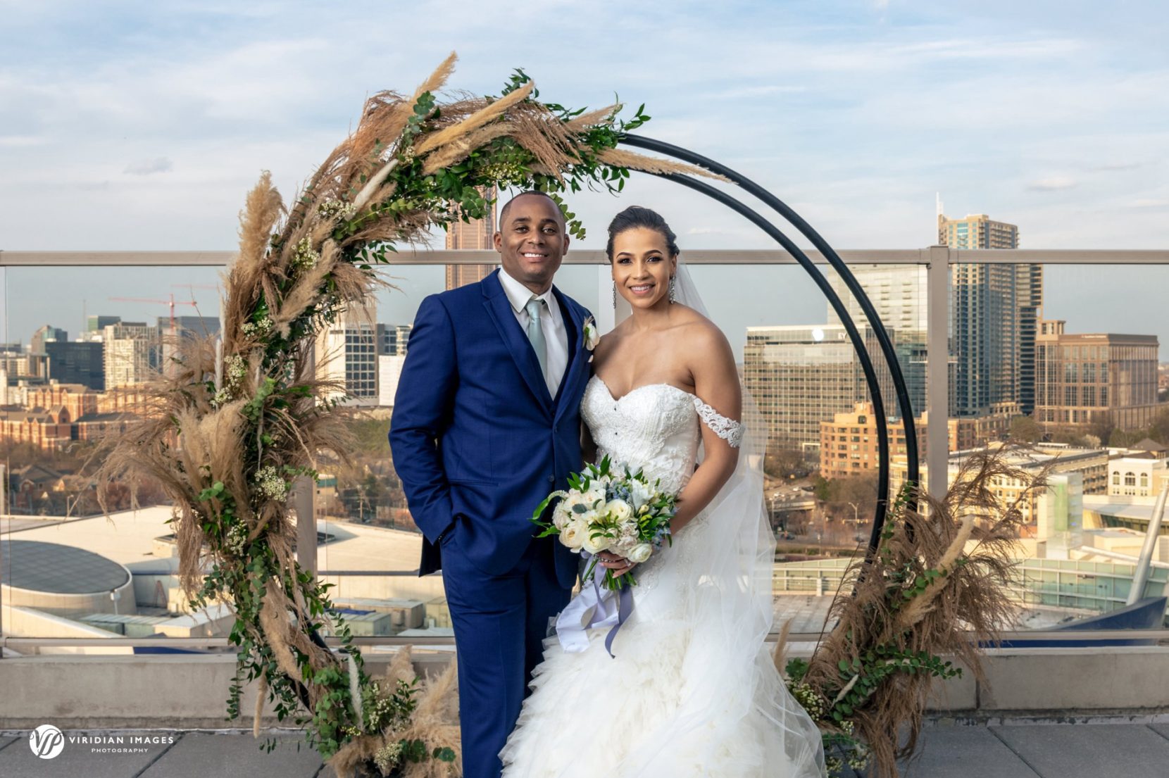 traditional portrait in front of circular flower installation on Ventanas Atlanta terrace after ceremony