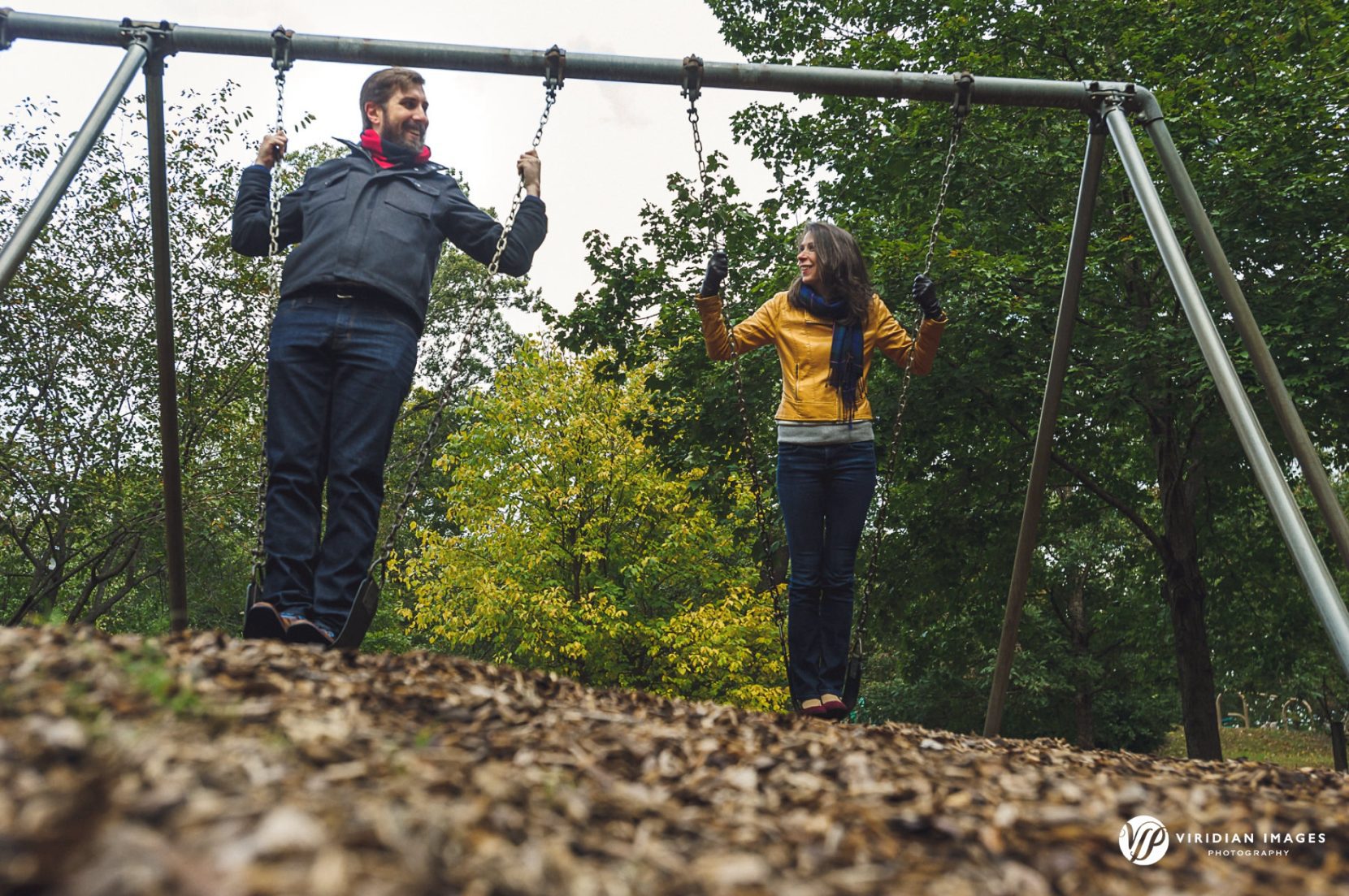Low angle ground level shot of Krista and Zach swinging together during their Grant Park fall engagement session.