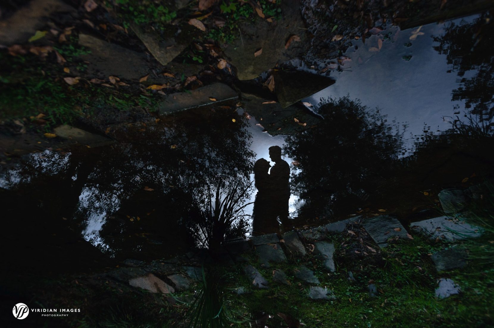 creative editorial photo of reflection of couple from rain puddle during engagement session in Atlanta