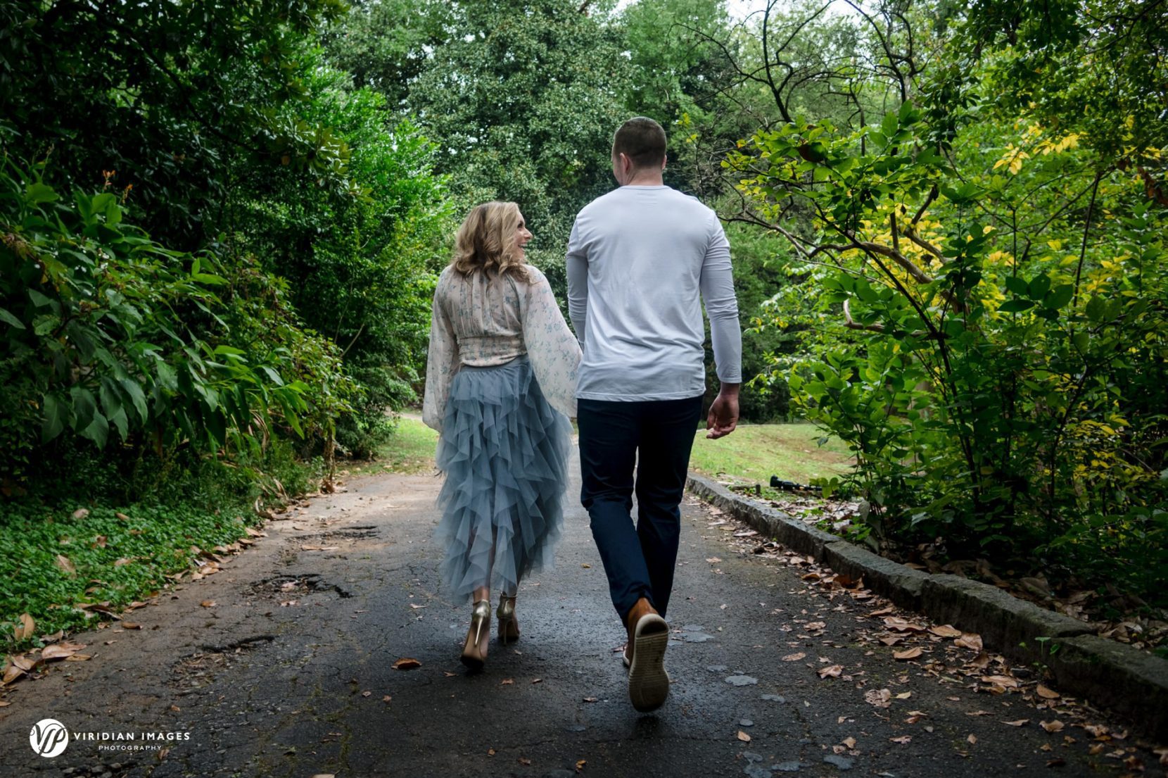couple walking away holding hands during Atlanta engagement session
