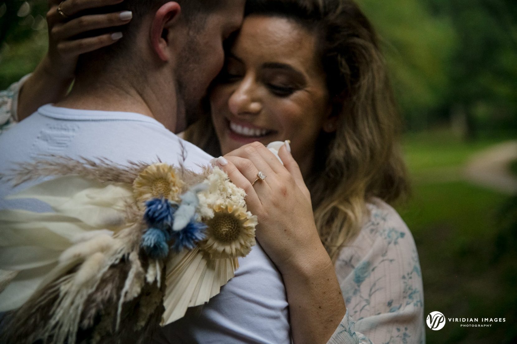 romantic portrait of couple hugging with feather flower bouquet