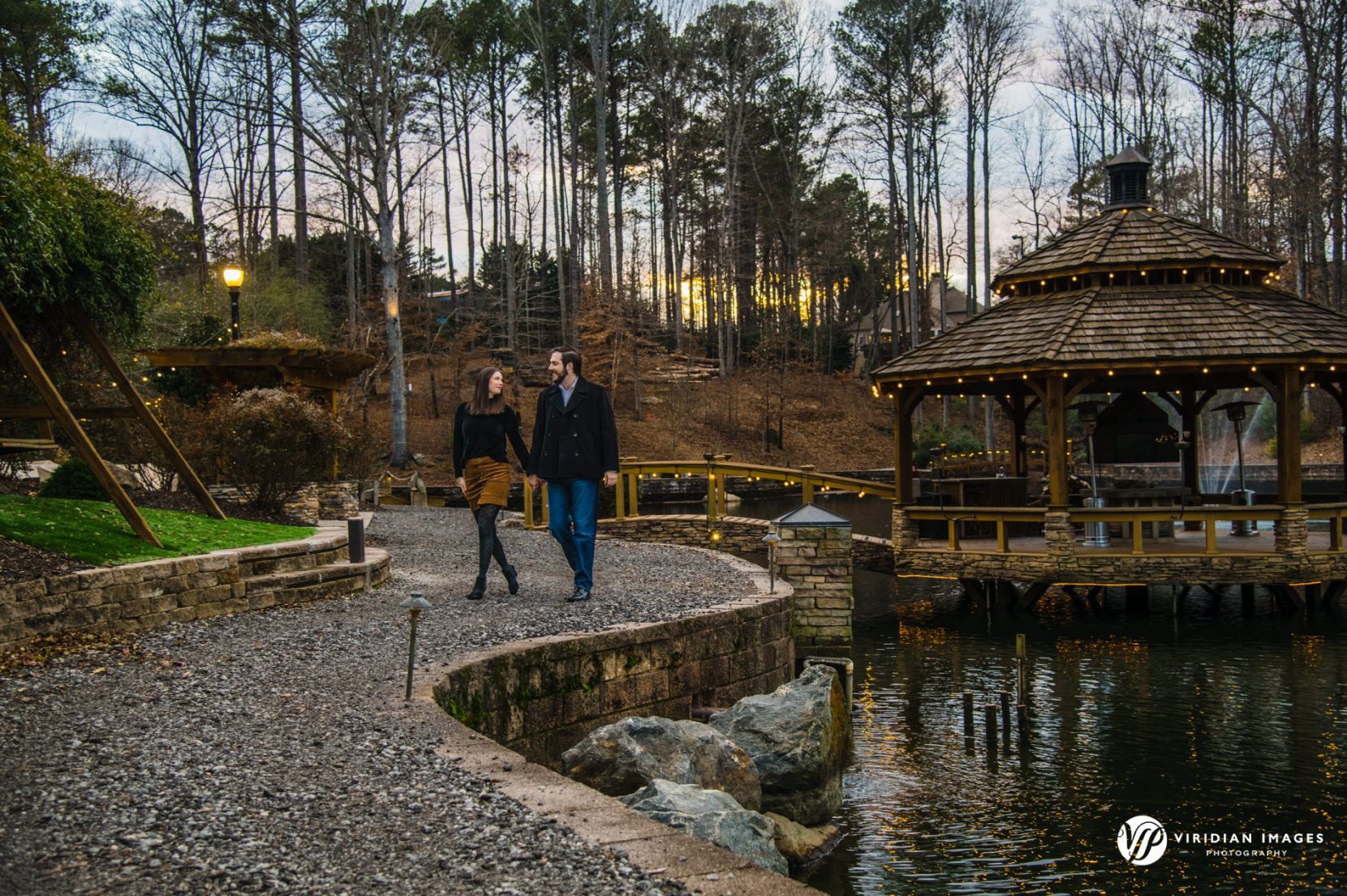 Couple walking down rocky path in front of gazebo at dusk at Rocky Lake.