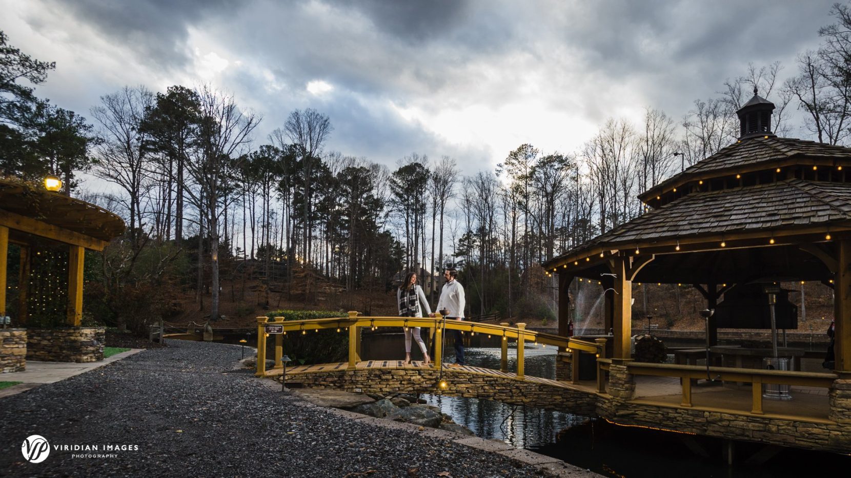 Winter engagement photo over wood bridge during blue hour at Rocky Lake Estate.